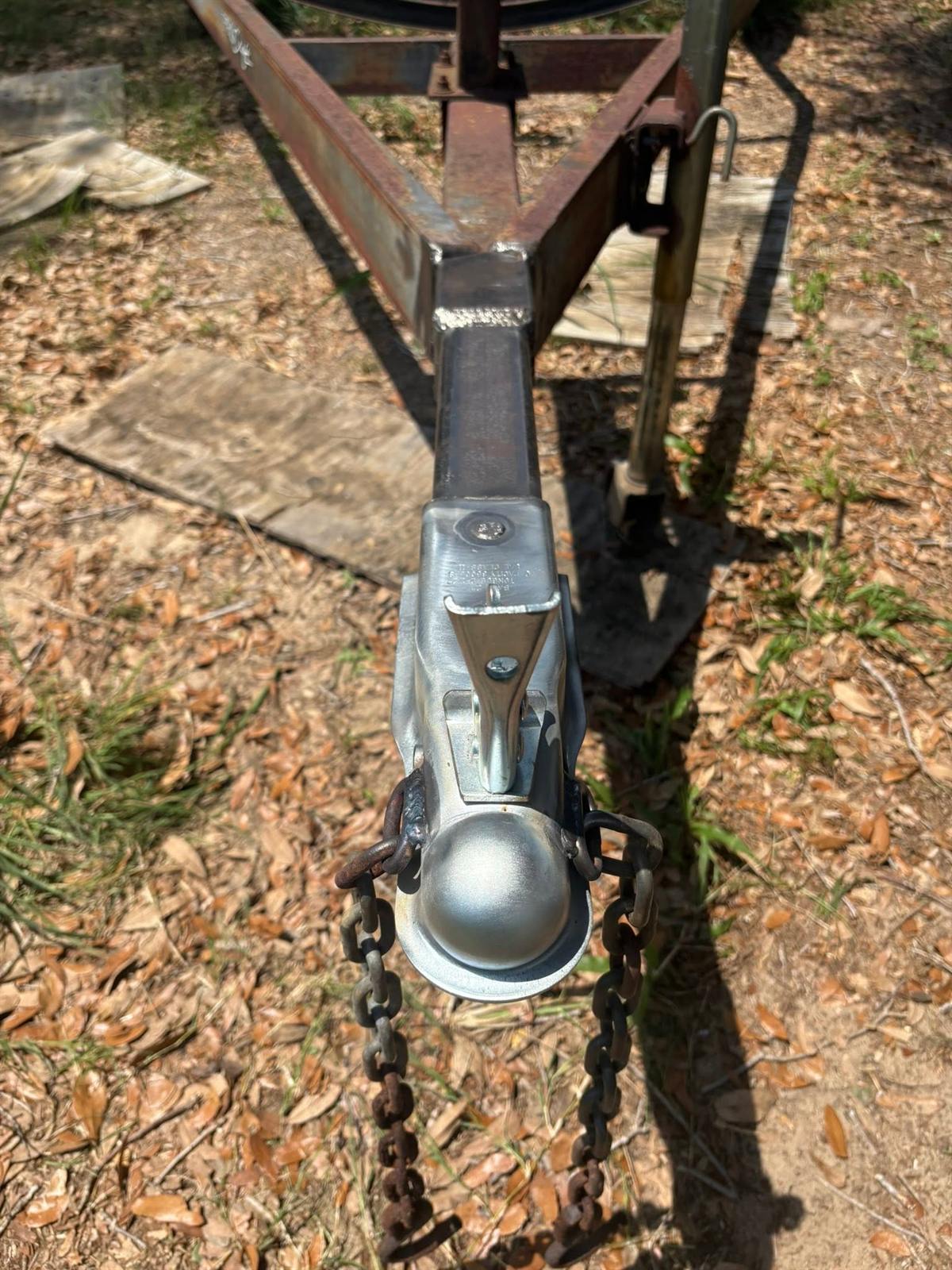Trailer tongue with a new coupler welded in place and safety chains attached